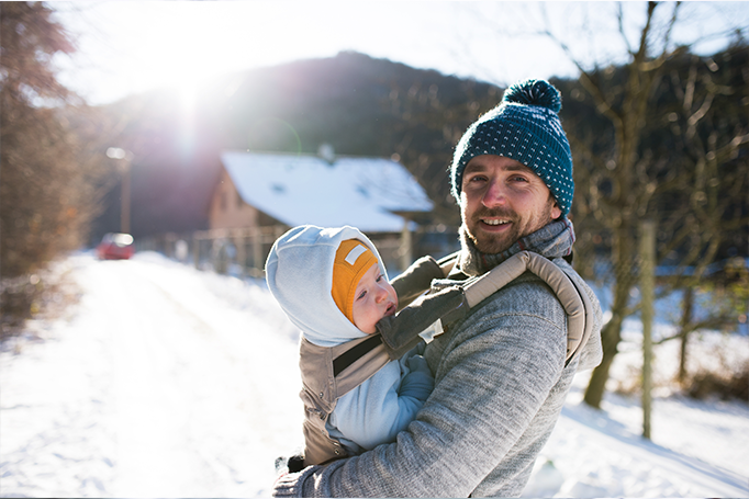 Man holding infant in the snow